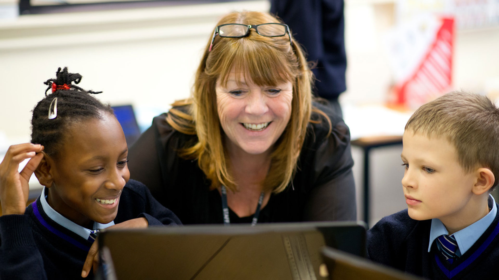 Member-of-staff-working-with-two-pupils-at-a-computer