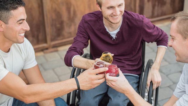 Three men in an outdoor location drinking alcohol