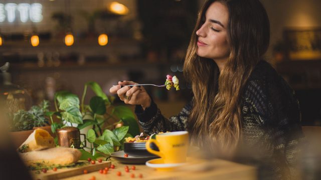 A woman in a restaurant eating a plate of food