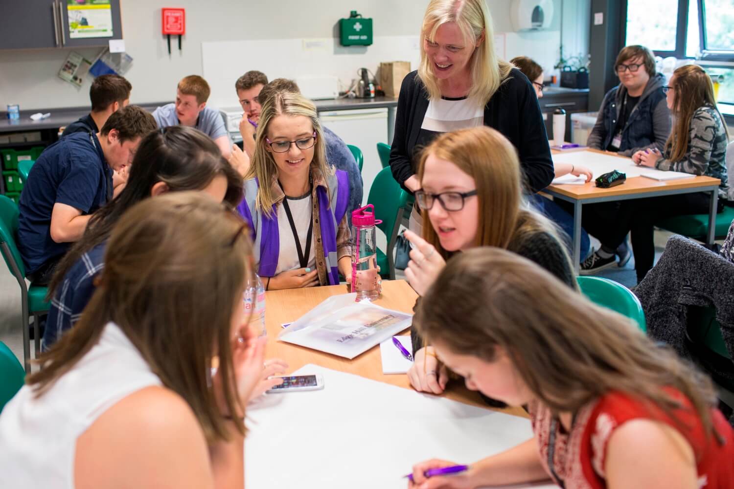 A student guide observes participants taking part in a classroom activity during a Year 12 residential.
