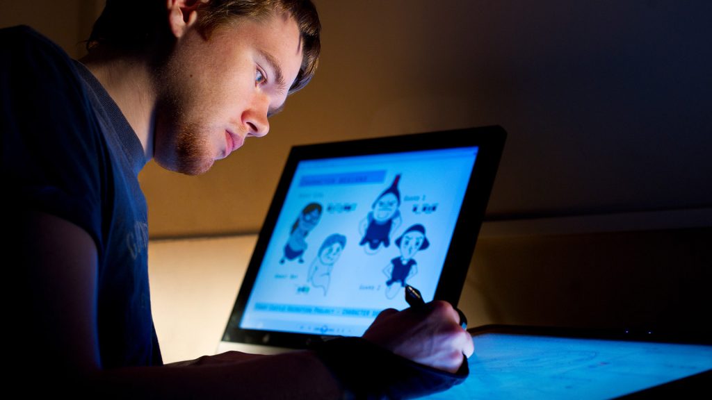 An animation student creating cartoons on a screen