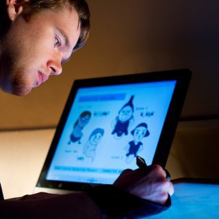 An animation student creating cartoons on a screen