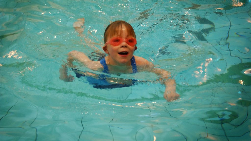 Child learning to swim in a swimming pool