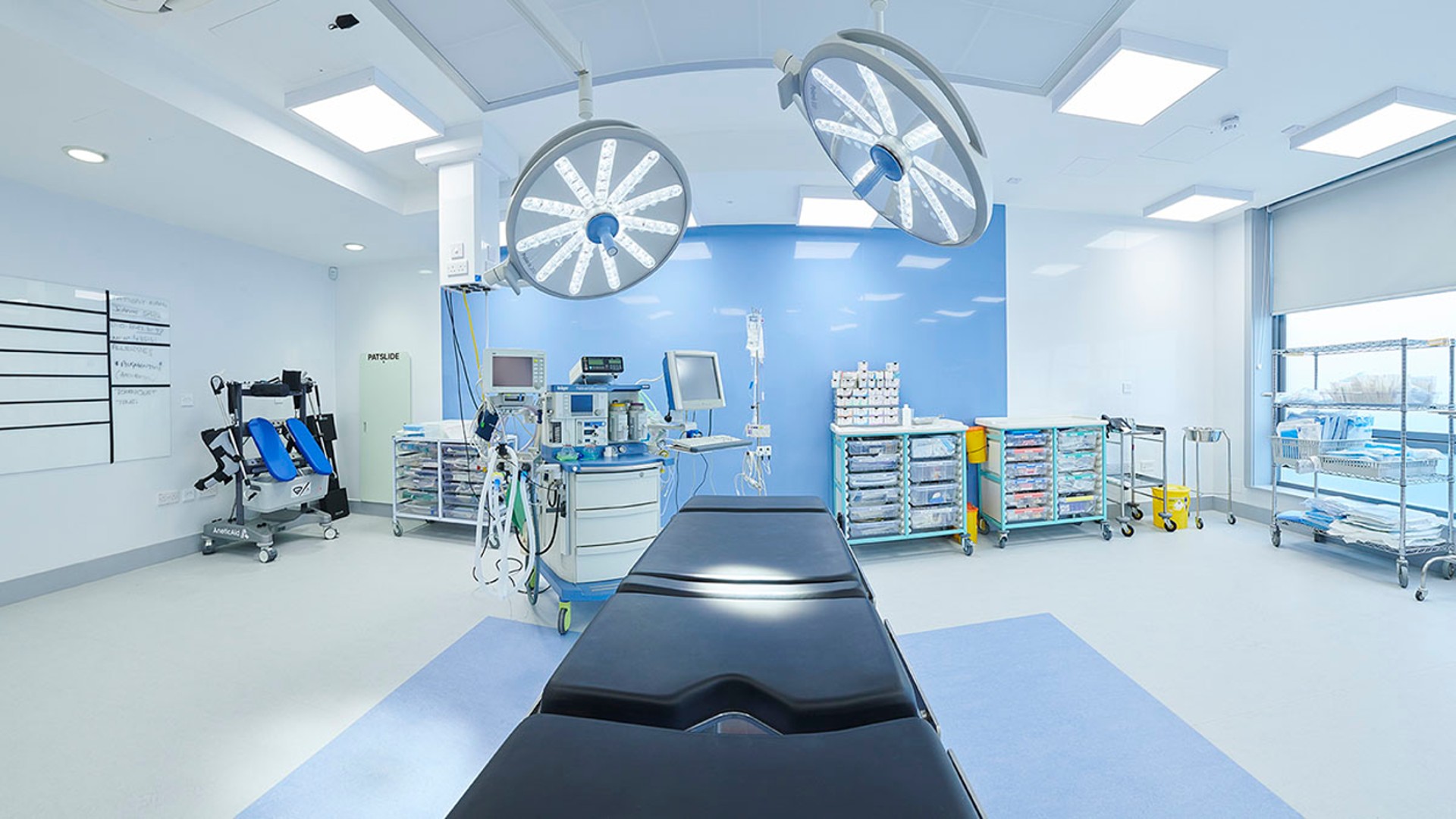 The simulation practice theatre area, this image includes an operating table in the foreground and various operating devices around it.