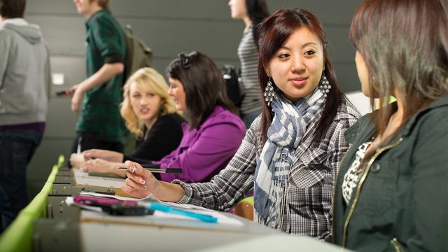 Two students talking in a lecture theatre