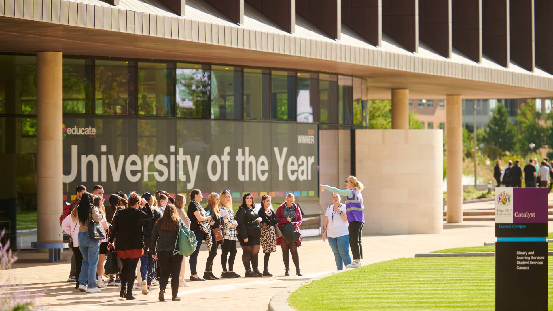 A group of people with a tour guide outside the Catalyst building.