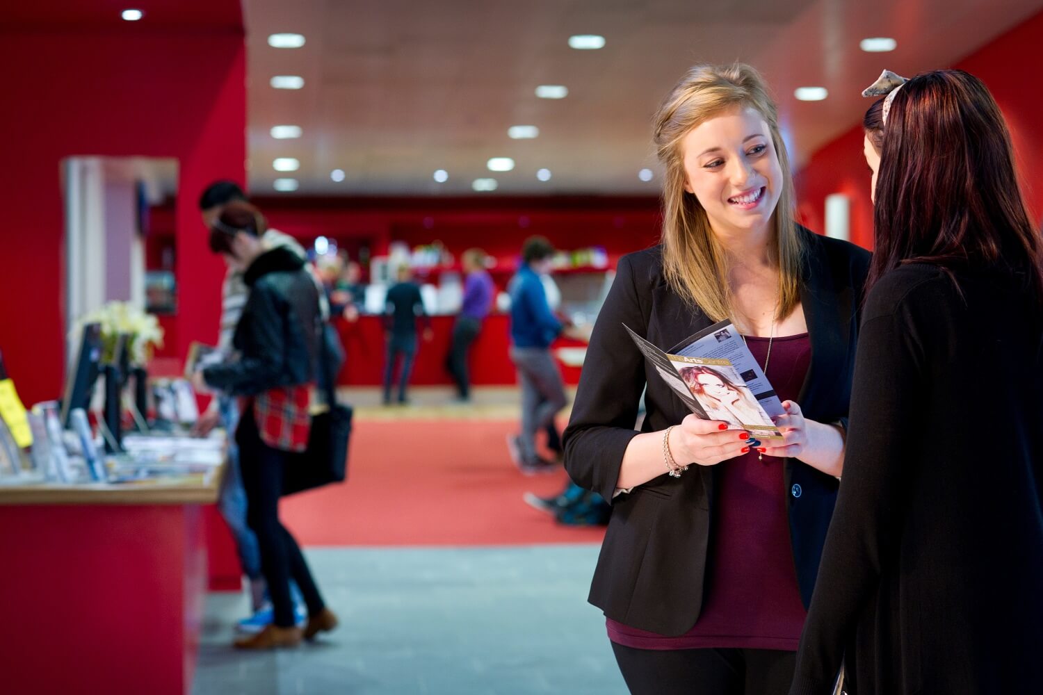 Students look through a what's on guide in the Arts Centre foyer.