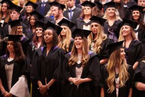 Graduate Jamie Legge stands in the lecture theatre ahead of his graduation ceremony.