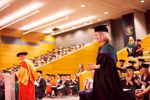A graduate prepares to walk along the red carpet and receive her award.