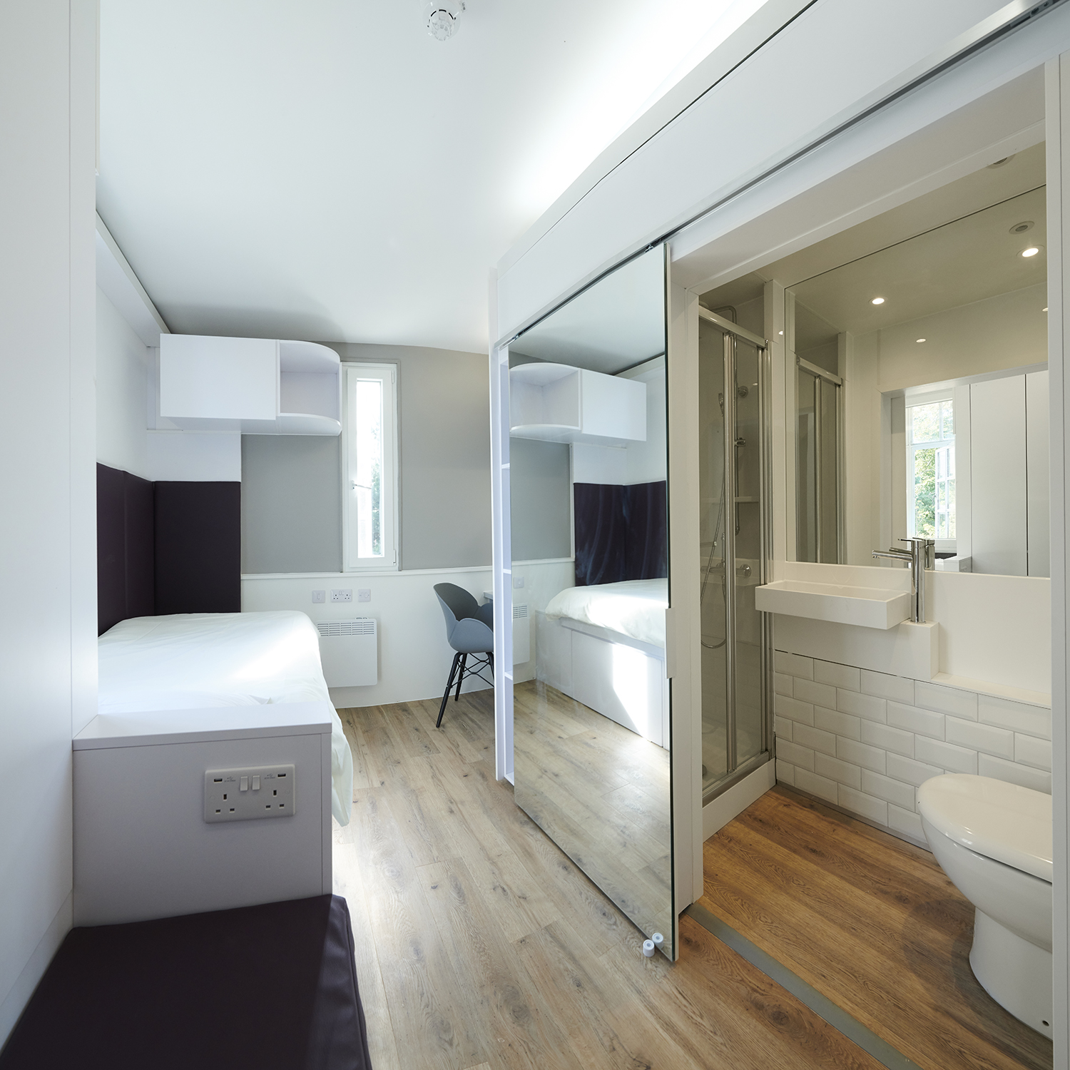 A full-length sliding mirror-door is pulled back to reveal the en-suite bathroom in a room in the eastern wing of Main Halls.