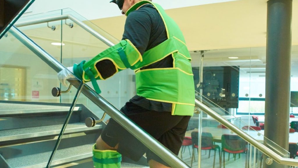 An image of a person wearing a bariatic suit walking up a set of stairs.