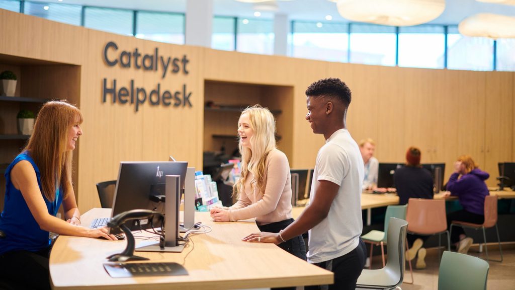 Two students talking to a member of staff at the Catalyst Helpdesk