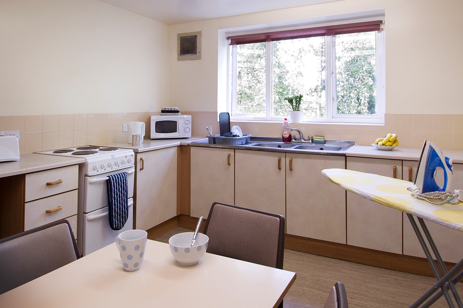 A kitchen in Forest Court with a table in the centre of the room.