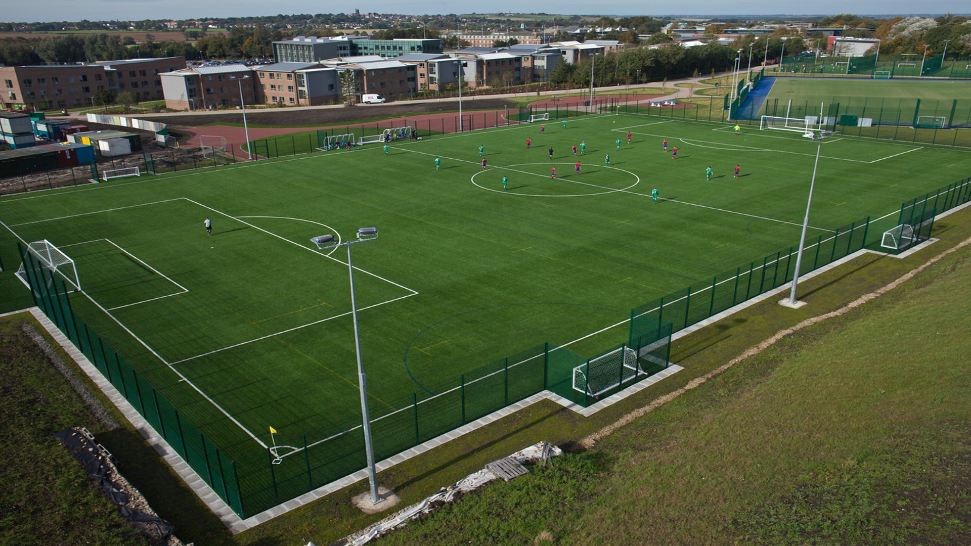 Aerial picture of several people stood on football pitch.