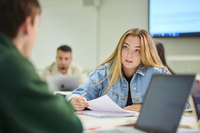 Two students working at a desk.