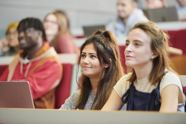 Two students listen attentively during a lecture.