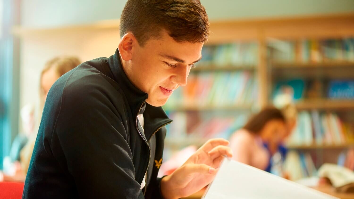 A student flicks through the notes in his file during a seminar.