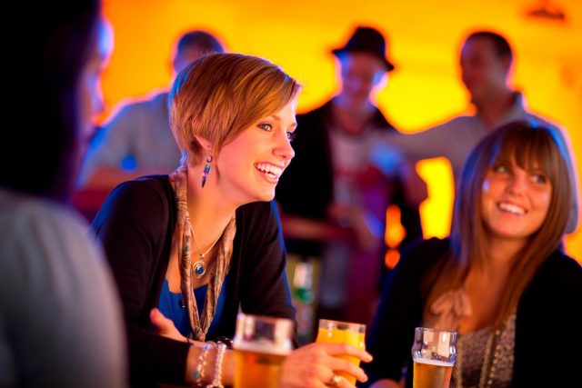 Two students enjoy drinks on a night-out on campus.