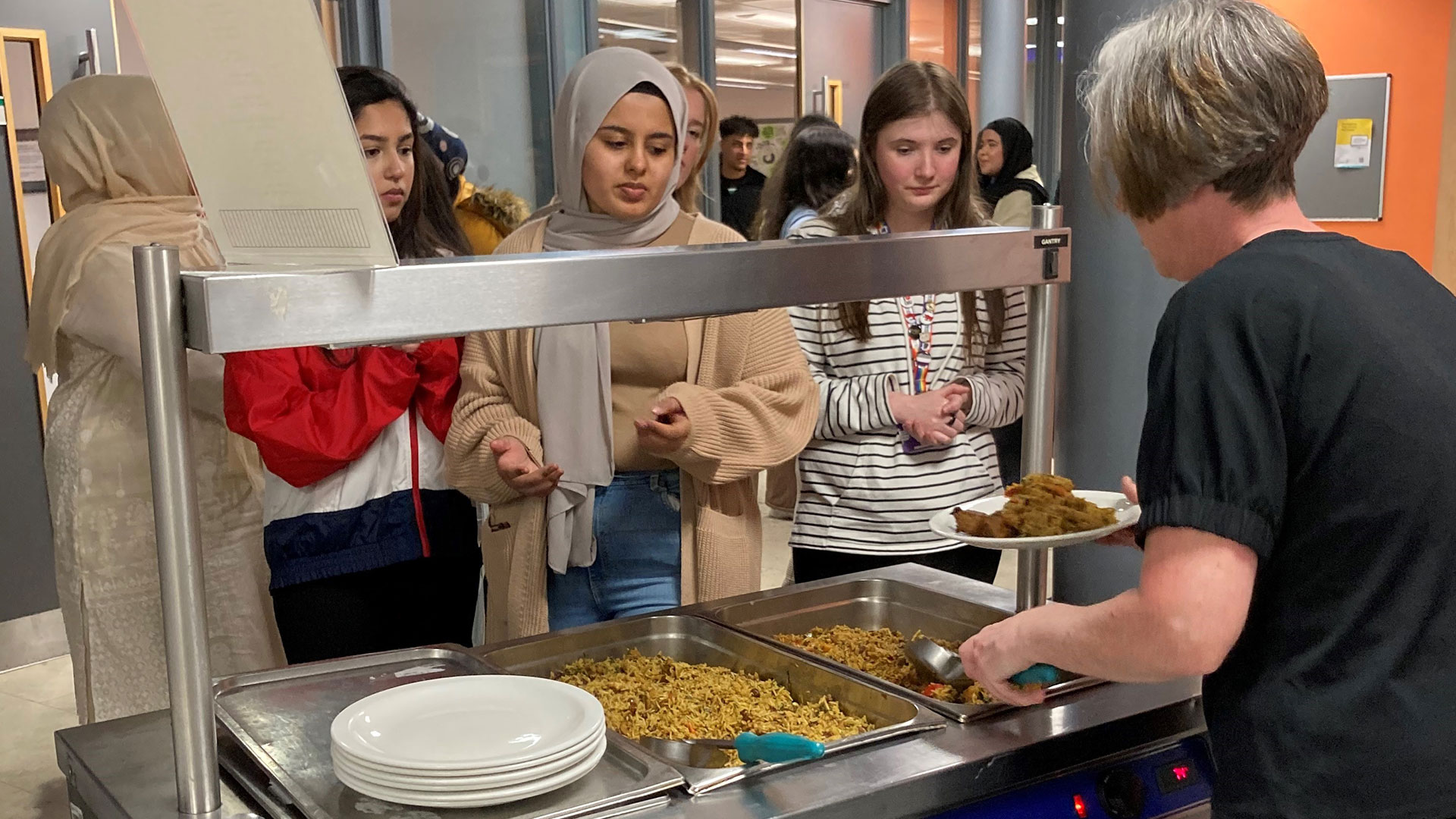 A group of students including a Muslim student purchase food.