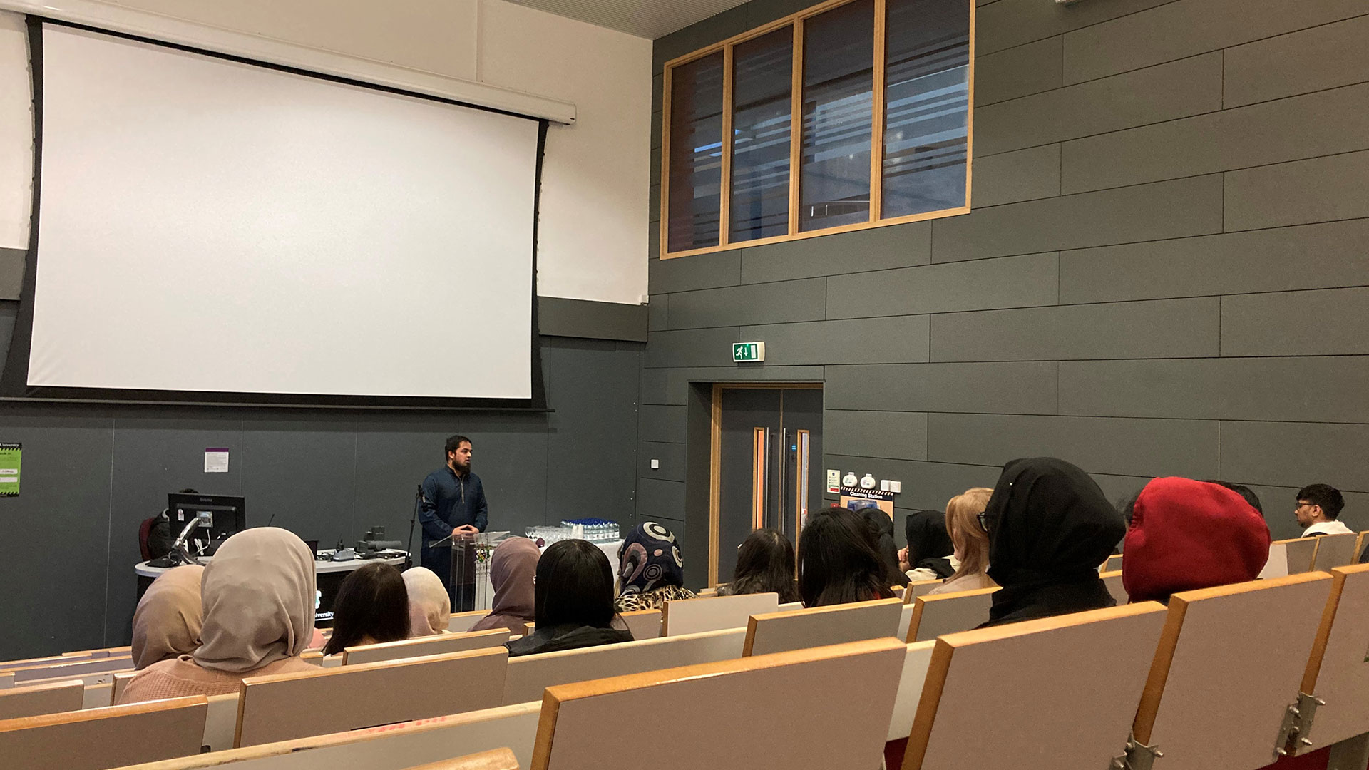 A group of Muslim students sit in a lecture theatre.