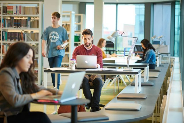 Students work on Macbooks in the University library.