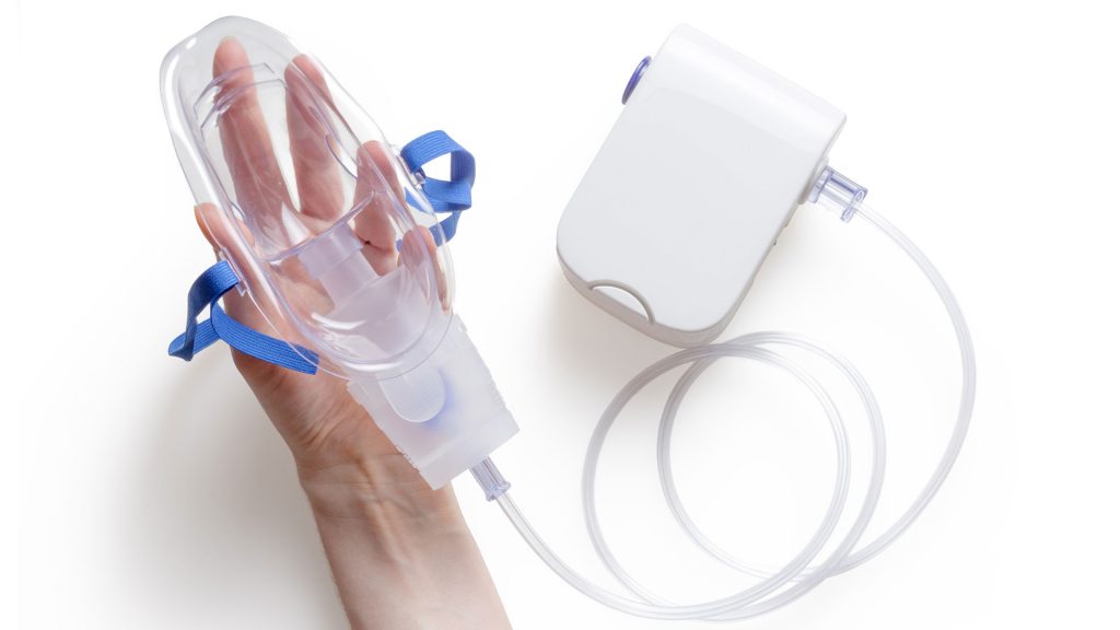 Clean medical inhaler in hand on white background