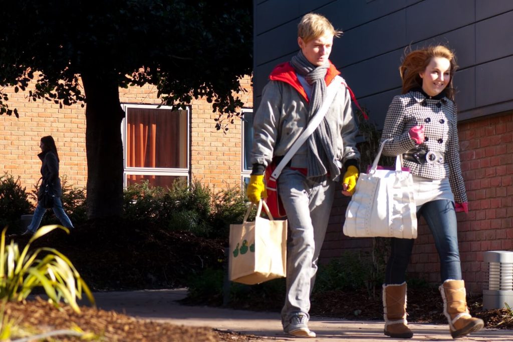 Two students carry bags of shopping near the Founders Court hall of residence.