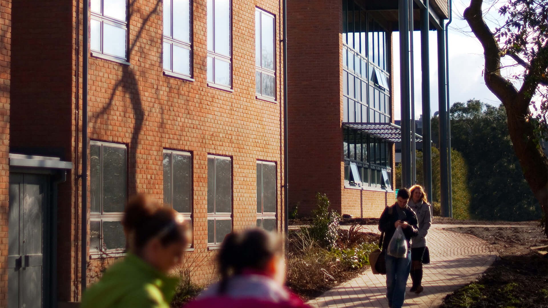 An image of people walking along a path outside one of the blocks of accomodation on the Edge Hill University campus.
