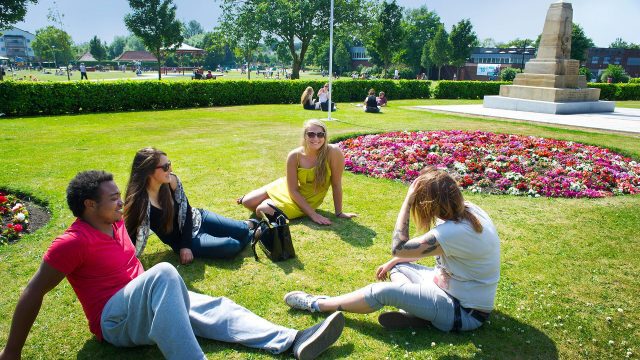 A group of people are sat on Coronation Park in Ormskirk. 