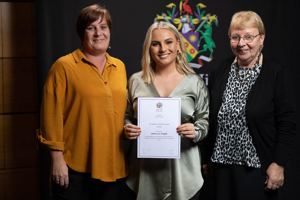 Academic Achievement Award winner Jamie-Lee Knight holds her certificate while attending a Scholarships Awards Evening with two members of her family.