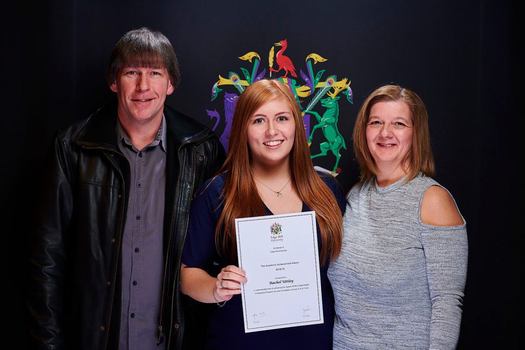 Academic Achievement Award winner Rachel Uttley holds her certificate while attending a Scholarships Awards Evening with her parents.