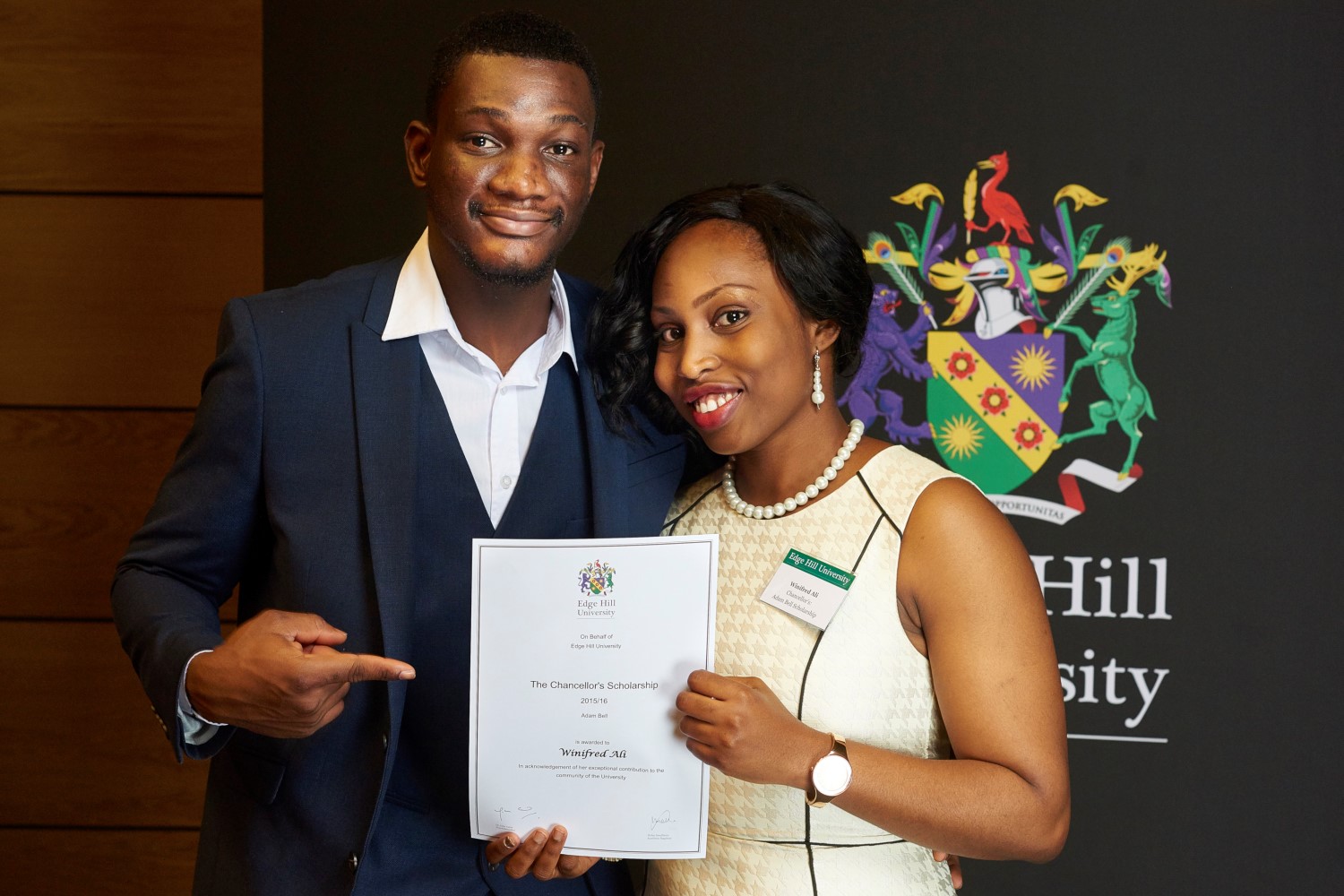 Student Winifred Ali, with her father, showing her University Scholarship Certificate at a Scholarship Awards Evening.