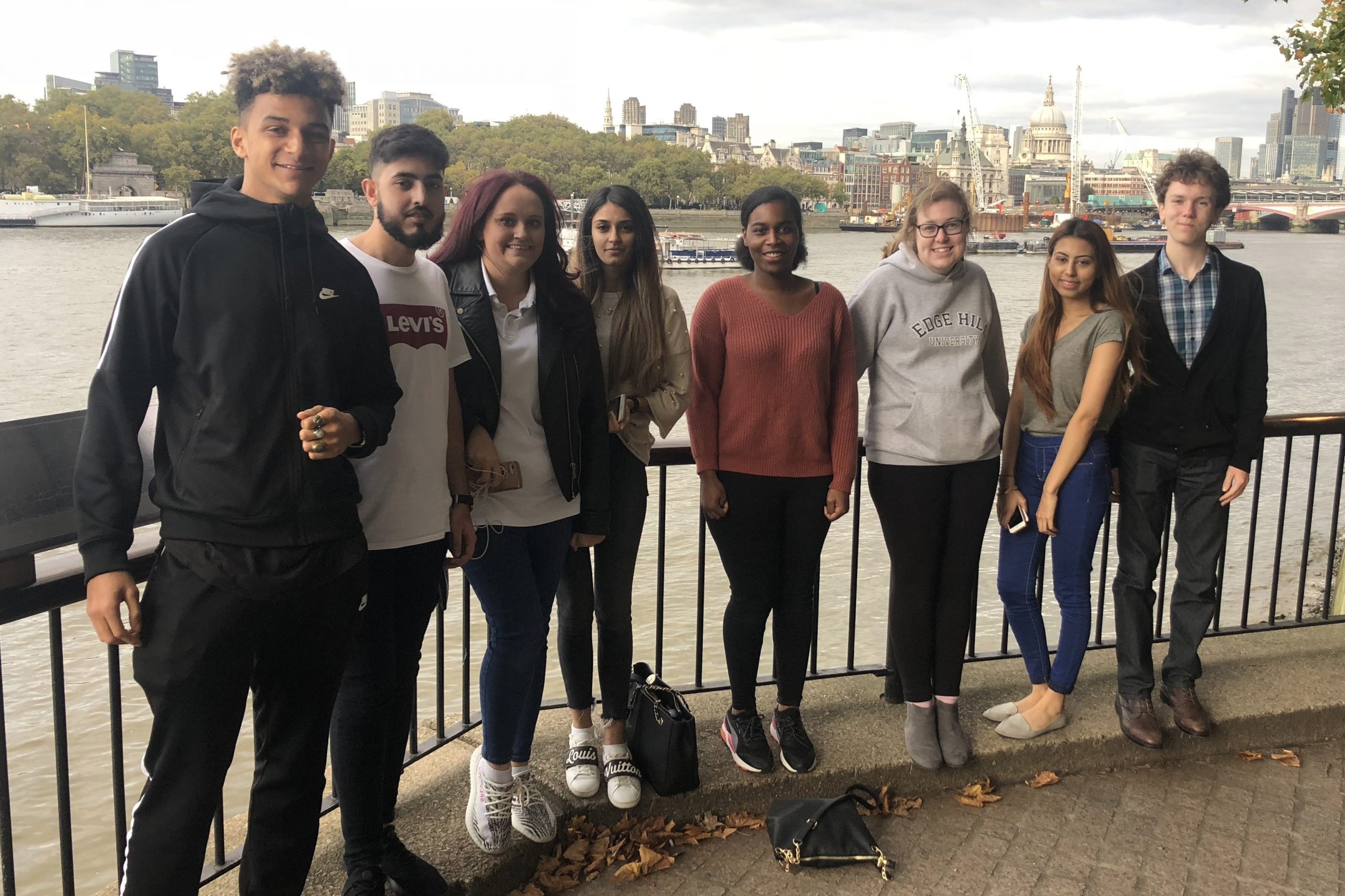 Eight students by the River Thames while on a visit to London to attend a graduate recruitment fair.