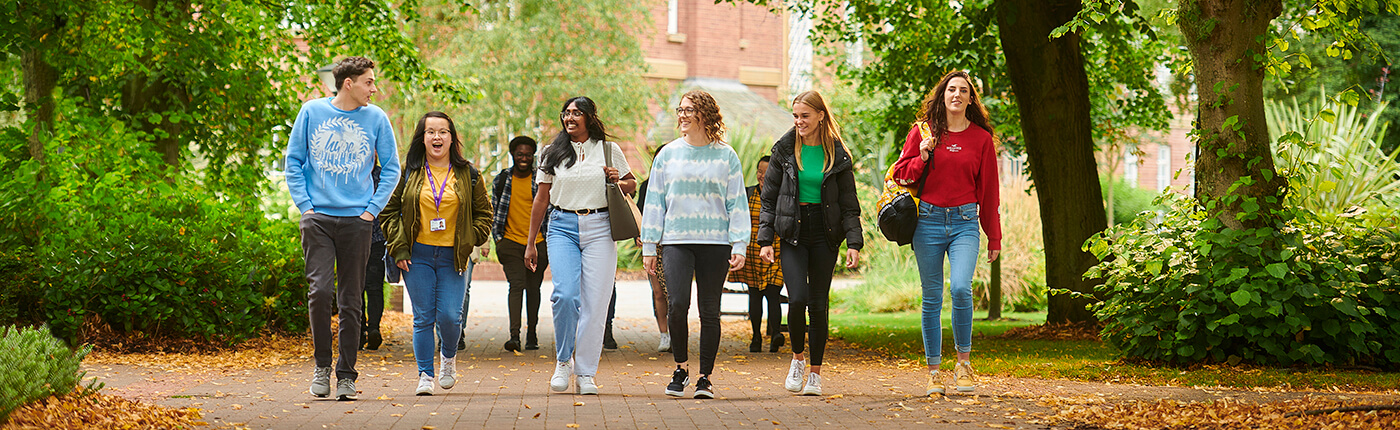 A group of six students walk round the campus.