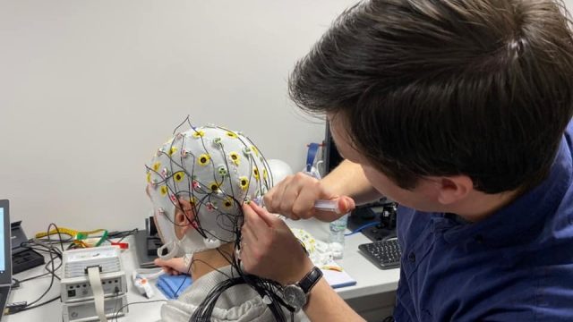 An image of a person hooking up neurological sensors toq another person.
