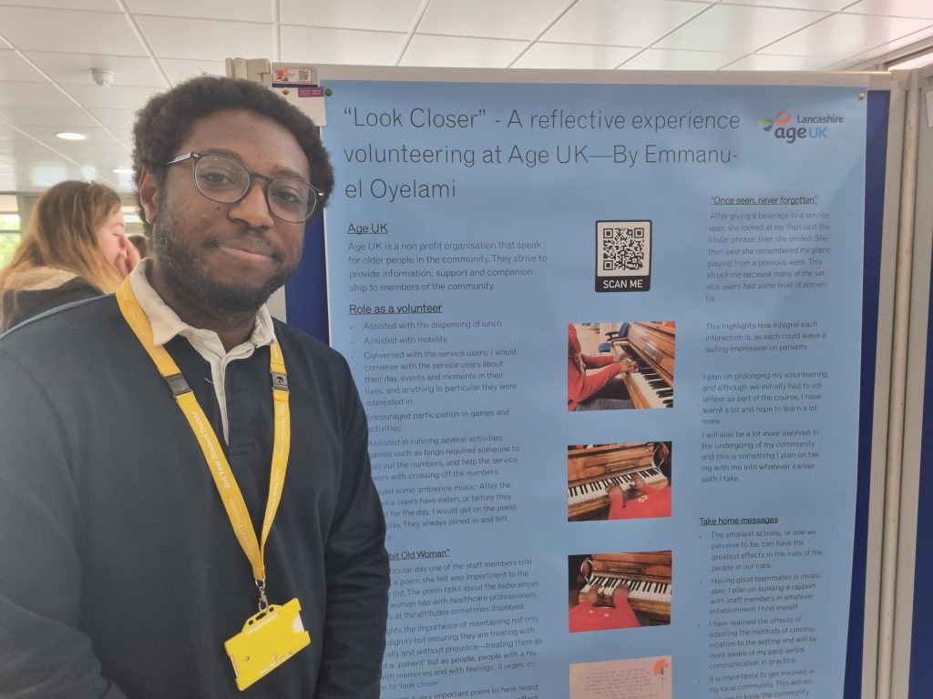 Image of Emmanuel Oyelami standing in front of presentation poster