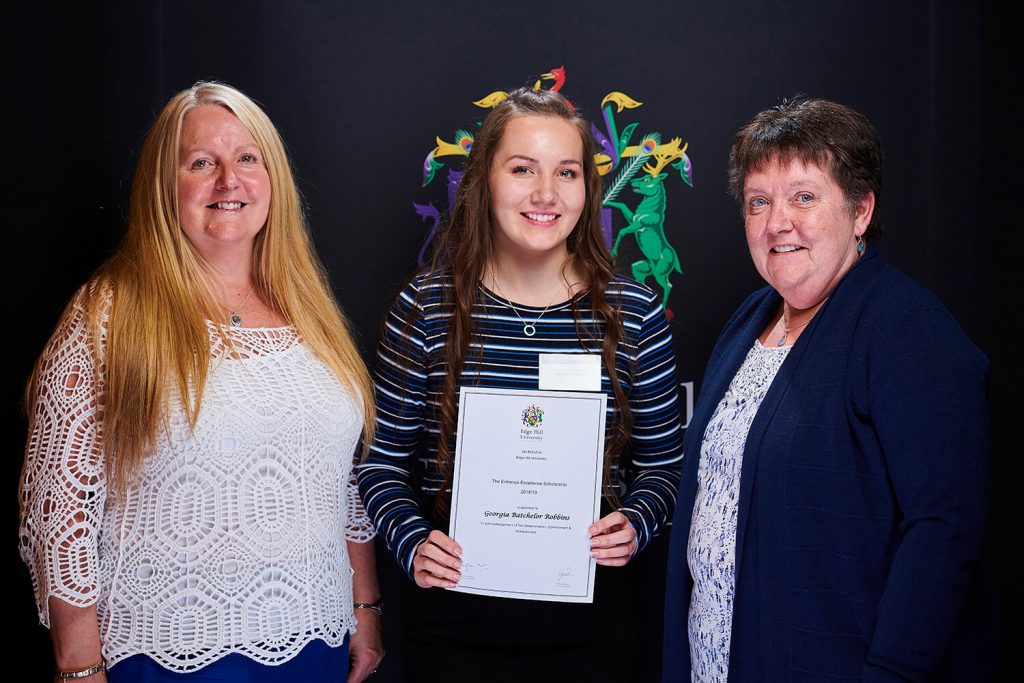 Excellence Scholarship winner Georgia Batchelor Robbins, with her family, shows her certificate at a Scholarship Awards Evening.