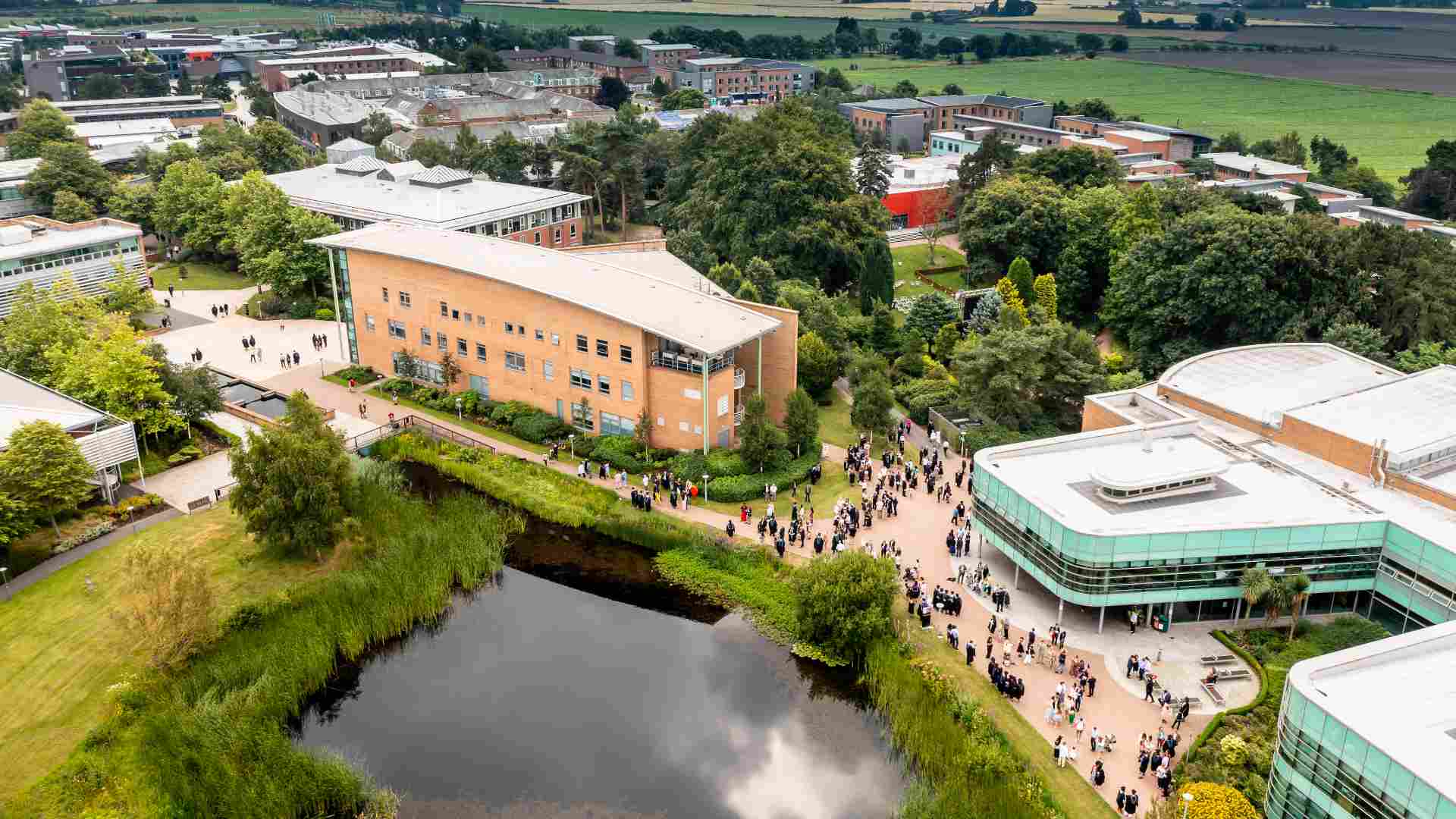 An aerial view of campus during graduation. The graduands are wearing their gowns ready to go into a ceremony.