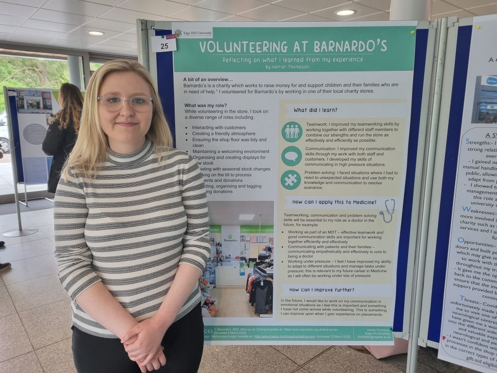 Medical student Harriet Thompson standing in front of her poster to share her experience of volunteering with Barnardo’s.