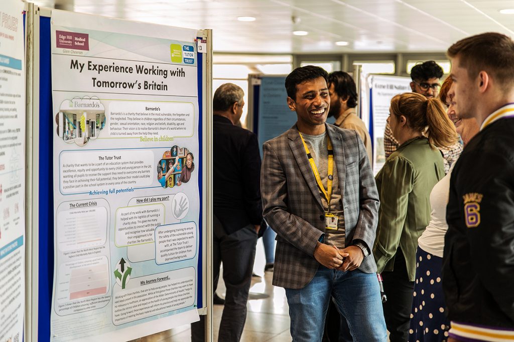 Student standing in front of conference poster