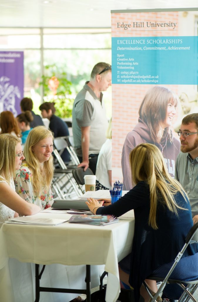 A supporter and their student sat at table receiving scholarships' advice at an open day.