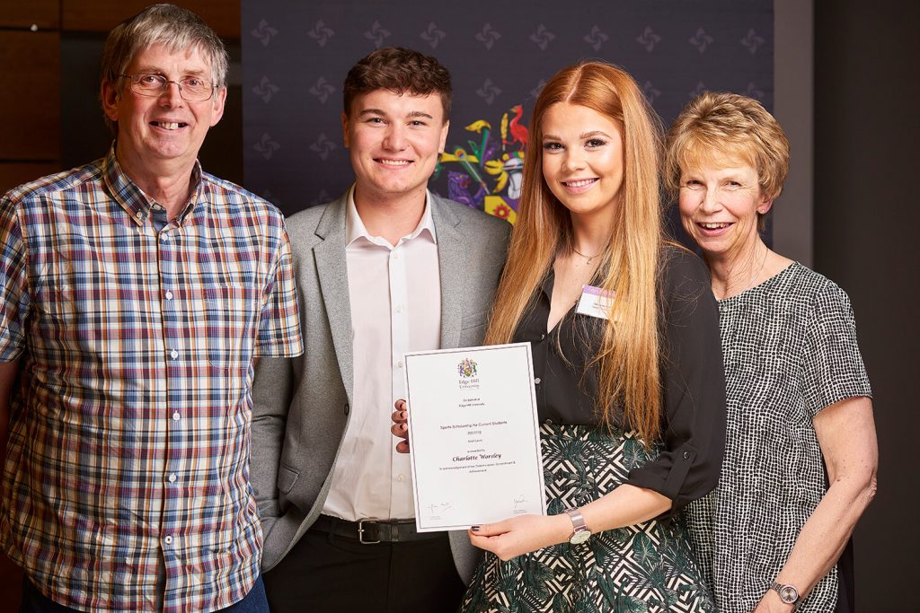 Sports Scholarship winner Charlotte Worsley, with family, showing certificate at a Scholarship Awards Evening.