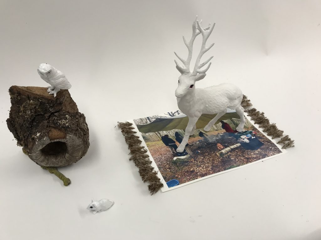A stag like figure on a rug with a log next to it. 