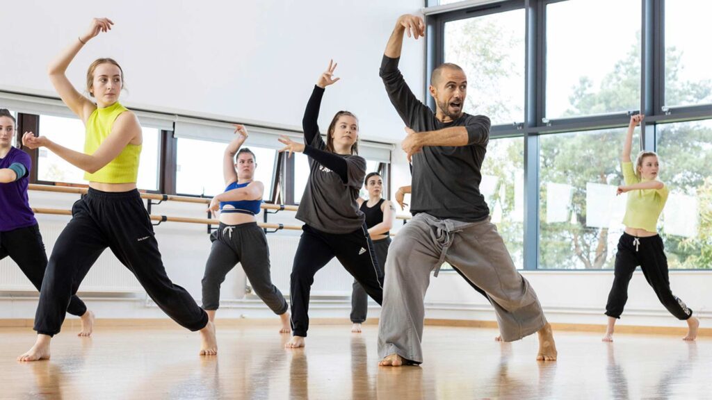 Six Performing Arts Students dancing with teacher at the front instructing the students