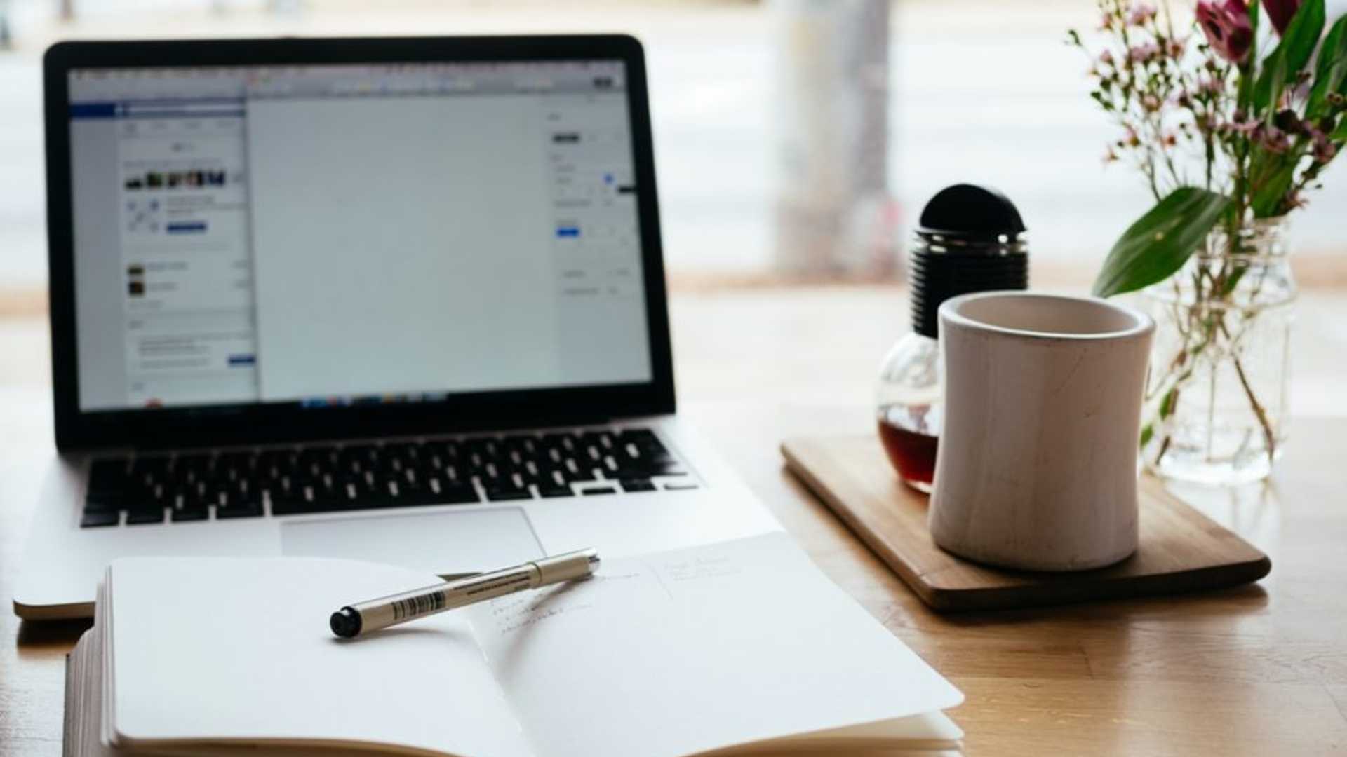 Laptop and notepad with pens ready for an online session to take place.