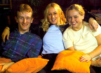 Three students sat together smiling