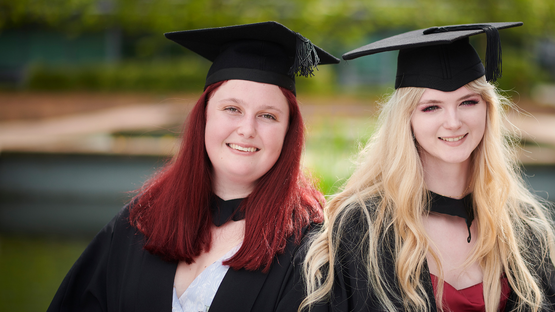 Becca Martlow and Niamh Hastings wearing caps and gowns and smiling