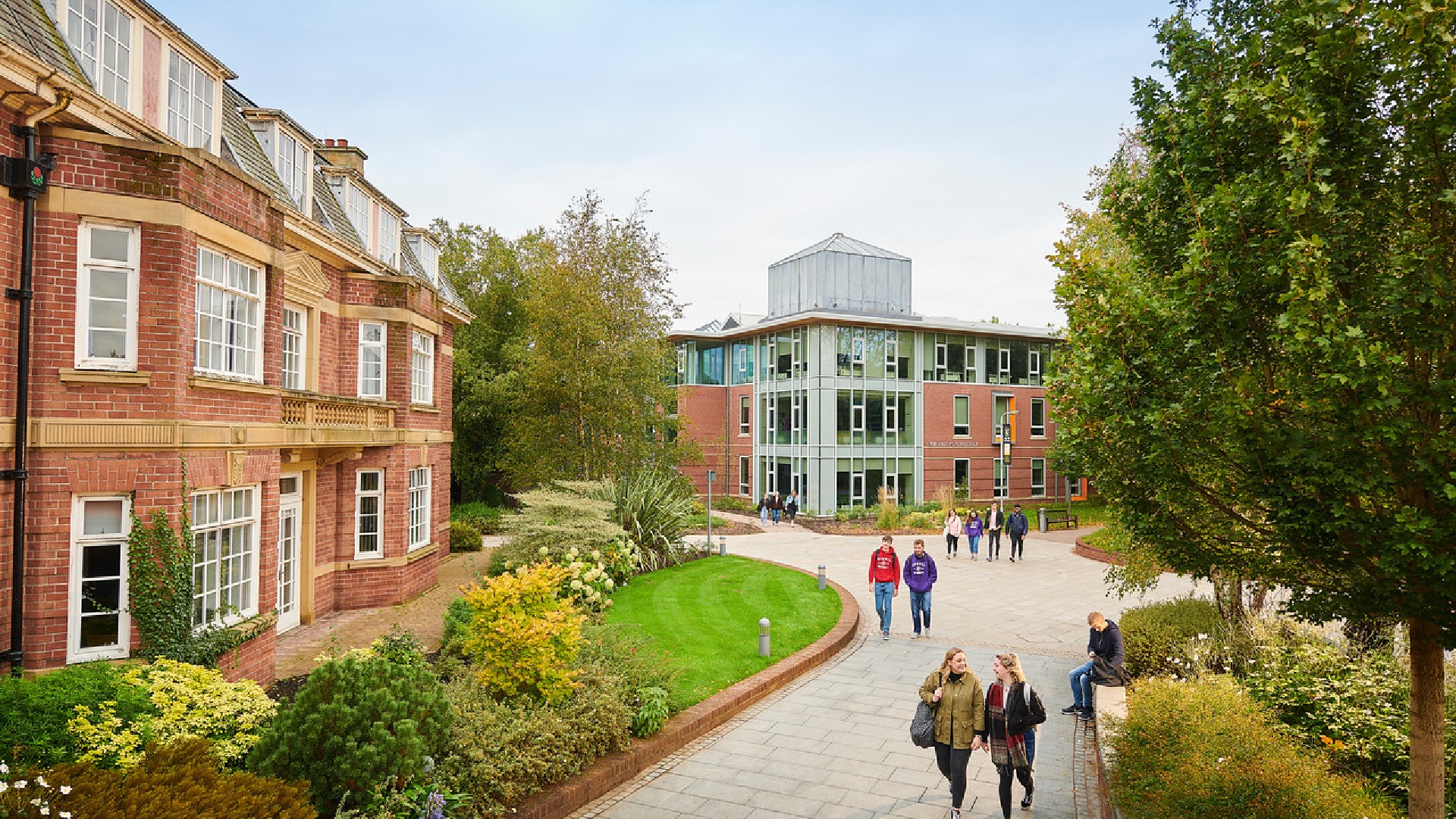 An image of multiple groups of people walking through Edge Hill Universities campus.
