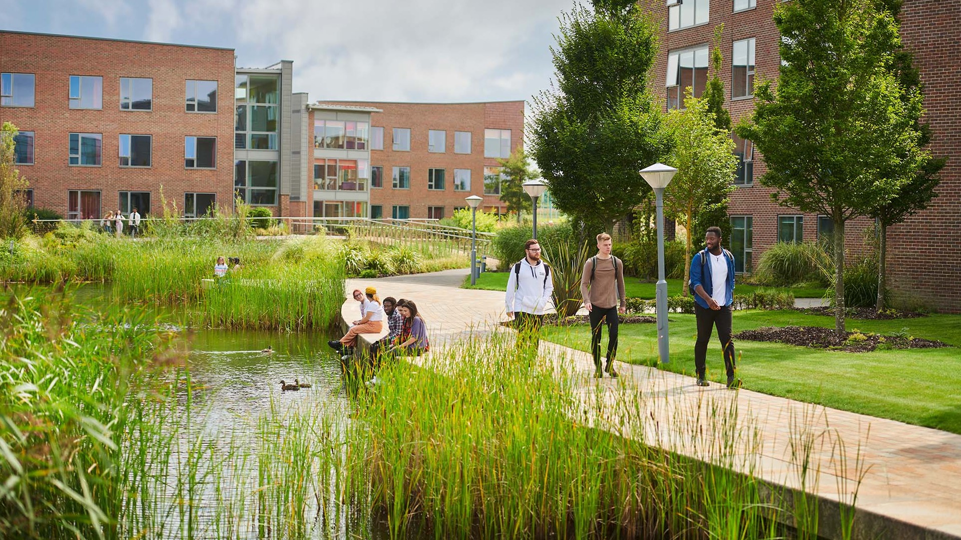 A group of students are walking through the Edge Hill University campus.