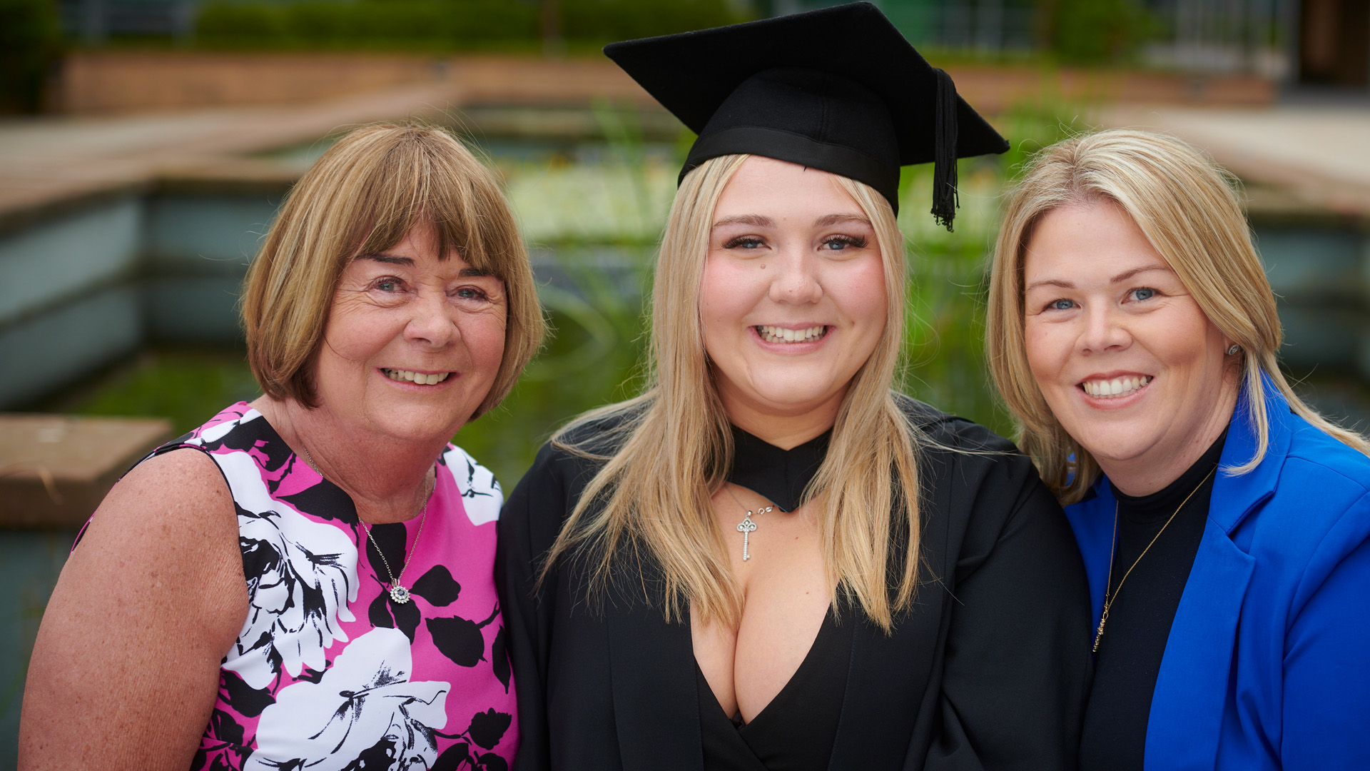 Three members of the Pendleton Nash family. The middle is a graduating student wearing a cap and gown.